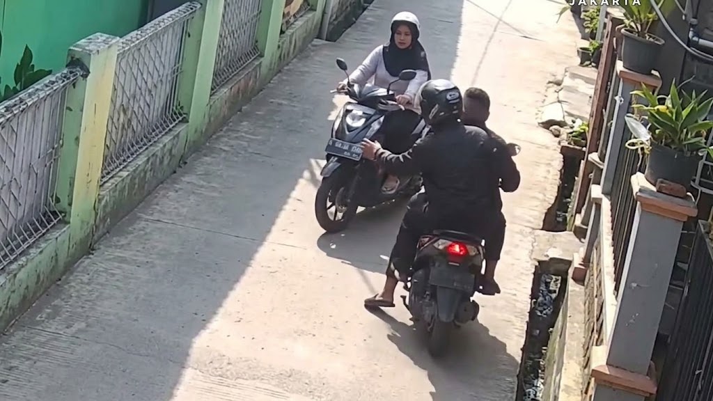 Saat pelaku berboncengan motor menjambret seorang ibu yang juga sedang mengendarai motor. (Foto: CCTV)